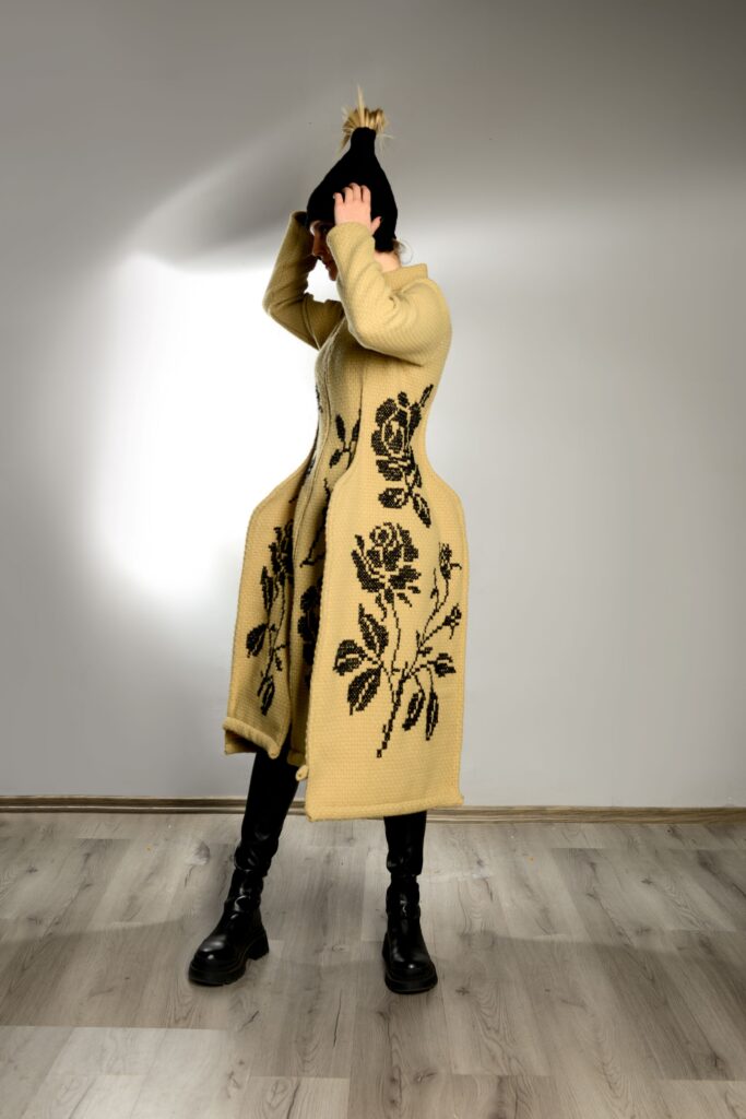 Model u žutom kaputu s crnim ružama iz kolekcije “Toplina šare” Ljiljane Majkić, nagrađena na Collegium Artisticum 2023 u kategoriji modnog dizajna