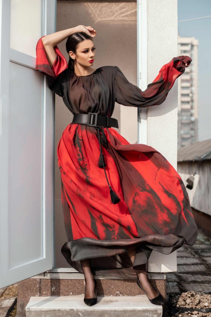 Model u crno-crvenoj haljini iz kolekcije “Red” dizajnerice Emine Husedžinović Ibrahimović, nagrađenoj na Collegium Artisticum 2022 u kategoriji modnog dizajna.